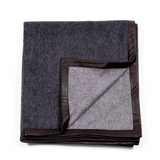Luxurious and soft black throw, made of cashmere, with exquisite black suede edges, revealing grey back side.