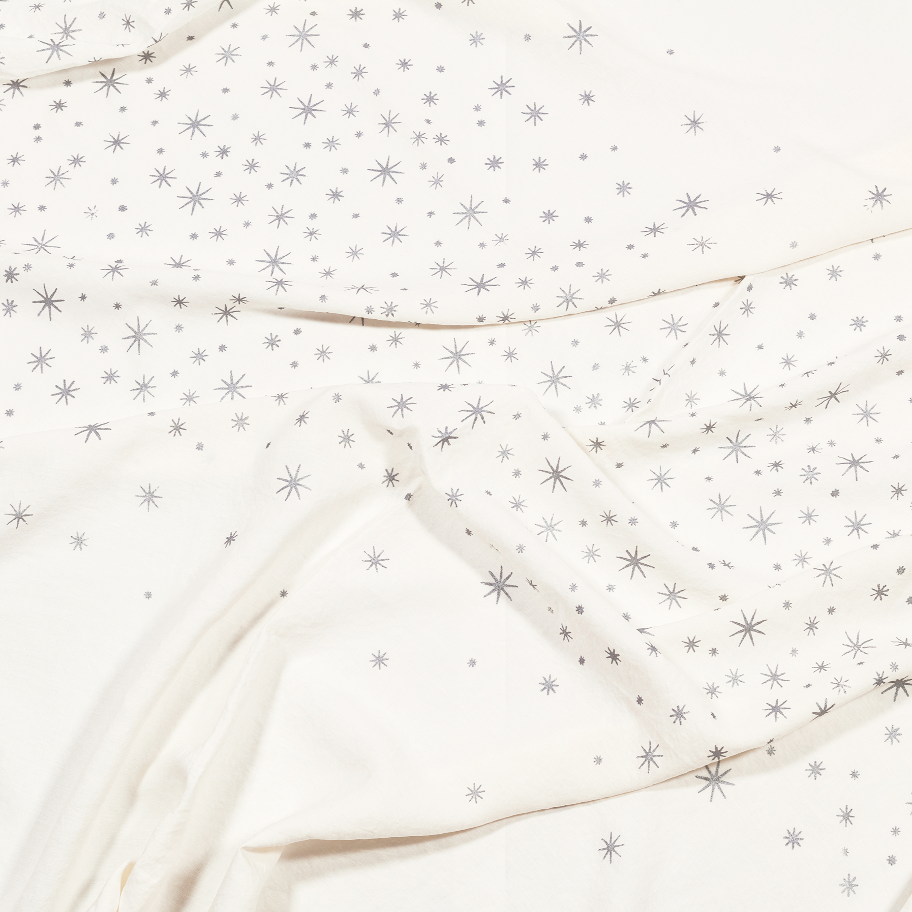 A luxurious white linen tablecloth with silver stars, perfect for adding a touch of elegance to your table.