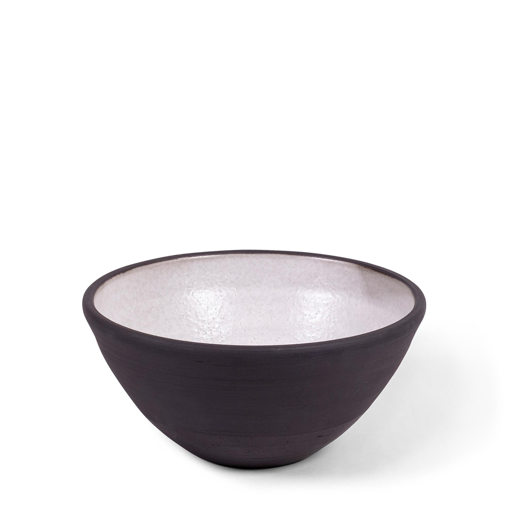 Handmade classic bowl combining raw blackware with off-white glaze. The piece features slight natural variations, adding to its unique beauty and elegance for your table.