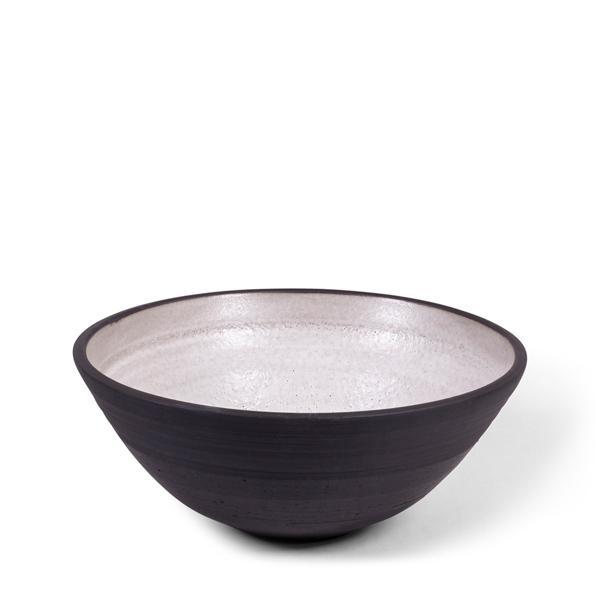 Large handmade serving bowl combining raw blackware with off-white glaze. The piece features slight natural variations, adding to its unique beauty and elegance for your table.