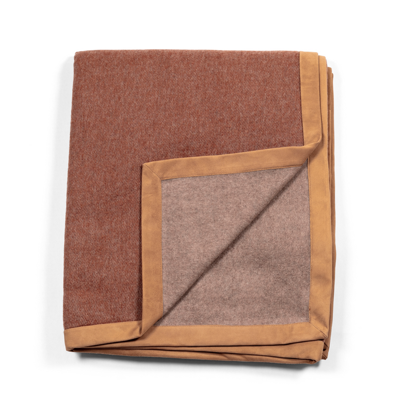 Luxurious and soft throw in terracotta tones, made of cashmere, with exquisite suede edges.
