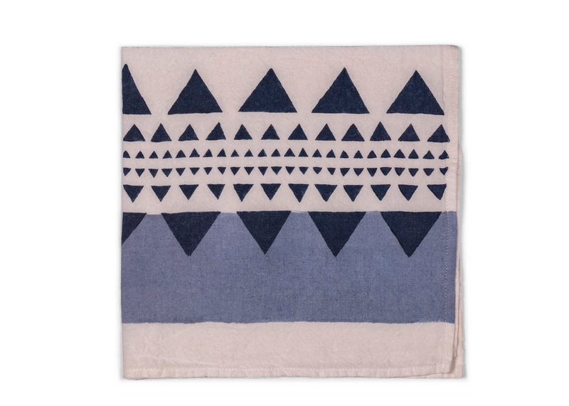 A folded napkin with a white base and dark blue geometric pattern, offering a striking blend of elegance and visual interest.