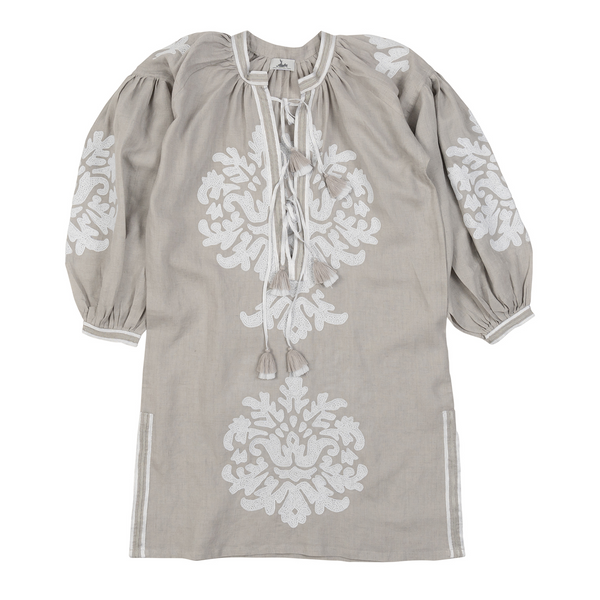 This grey dress with a hand-embroidered motif, made from 100% linen in Morocco and complemented by white striped trim and a tiered tassel, reflects timeless elegance and makes a statement piece for an evening out or casual day look.