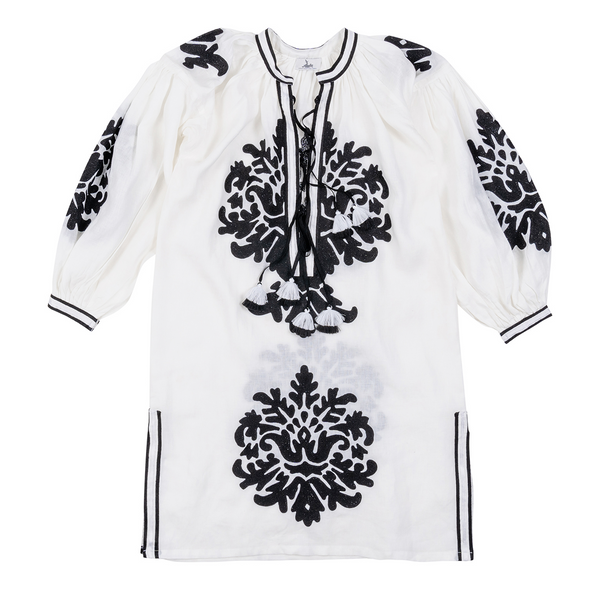This white dress with a hand-embroidered motif, made from 100% linen in Morocco and complemented by black striped trim and a tiered tassel, reflects timeless elegance and makes a statement piece for an evening out or casual day look.