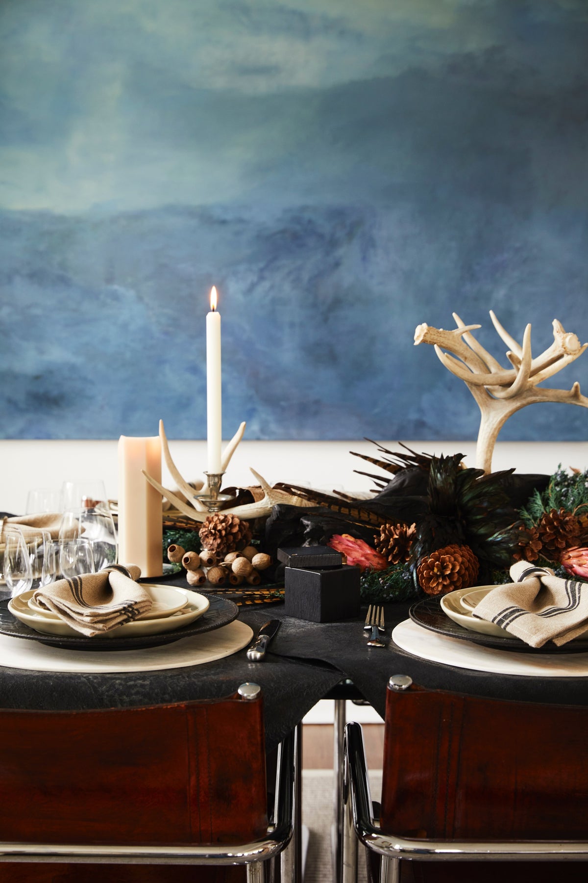 Autumn table with candles, pinecones and antlers