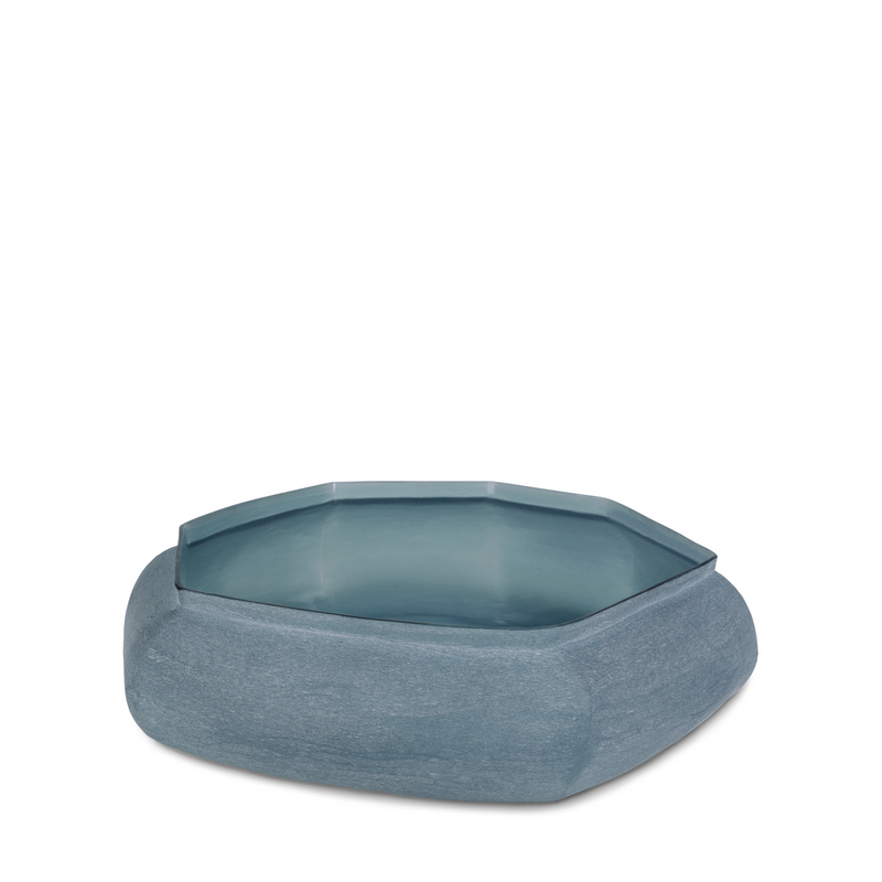 Karakol Bowl Indigo is made of glass, and has a special, stone like texture and a soft blue hue, giving off a unique sense of nature and contemporary artistry. Its striking faceted form makes it a luxurious addition to your home decor.