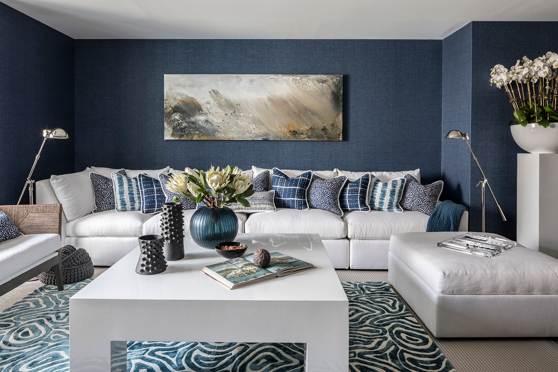 Modern living room with a white sectional sofa, coffee table, and decorative elements.