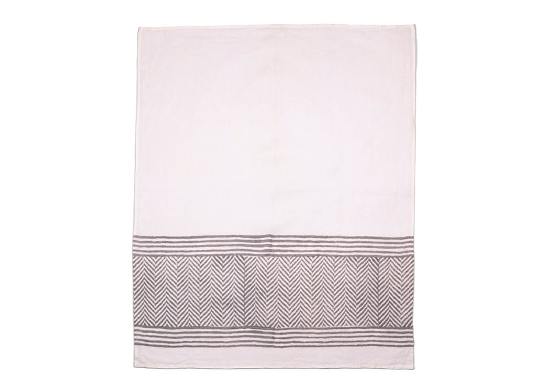 Unfolded tea towel revealing white base and soft grey chevron pattern, making any table or kitchen look cozy and comfortable.